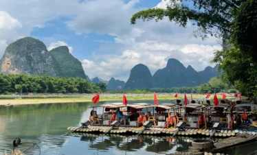 Private tour hero image of bamboo rafting on Yulong River in Yangshuo with countryside and karst peaks