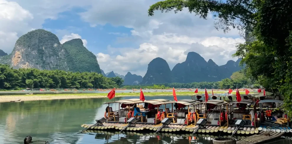 Private tour hero image of bamboo rafting on Yulong River in Yangshuo with countryside and karst peaks