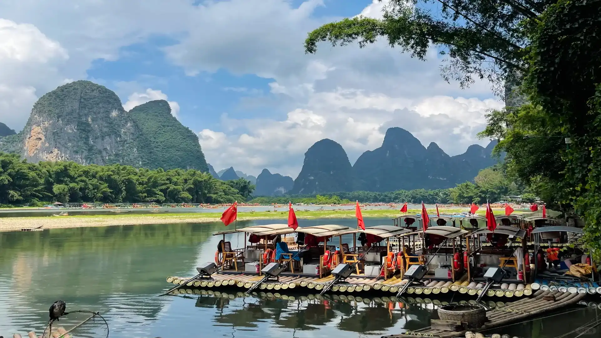 Private tour hero image of bamboo rafting on Yulong River in Yangshuo with countryside and karst peaks
