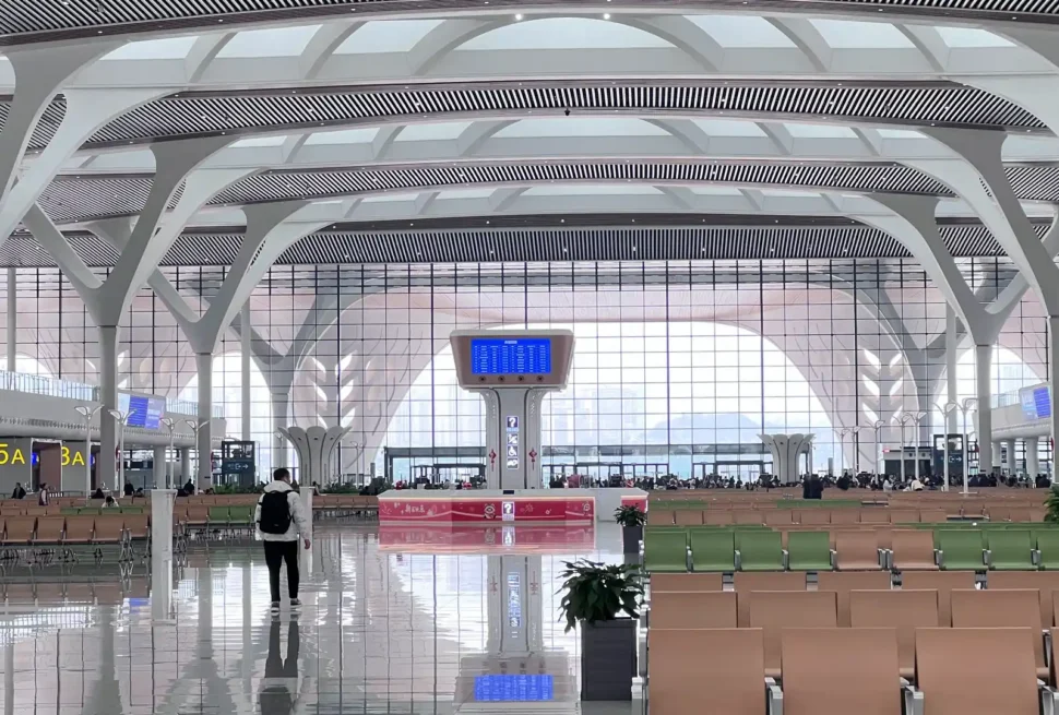 First-time traveler checking boarding information inside a China high-speed railway station