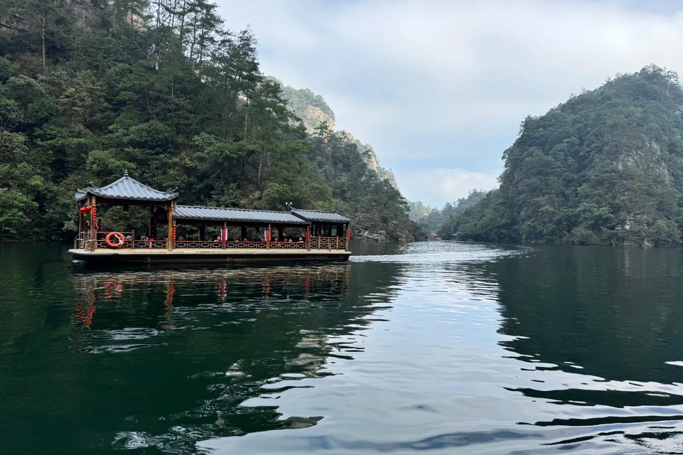 Scenic boat ride on Baofeng Lake surrounded by steep green karst peaks.